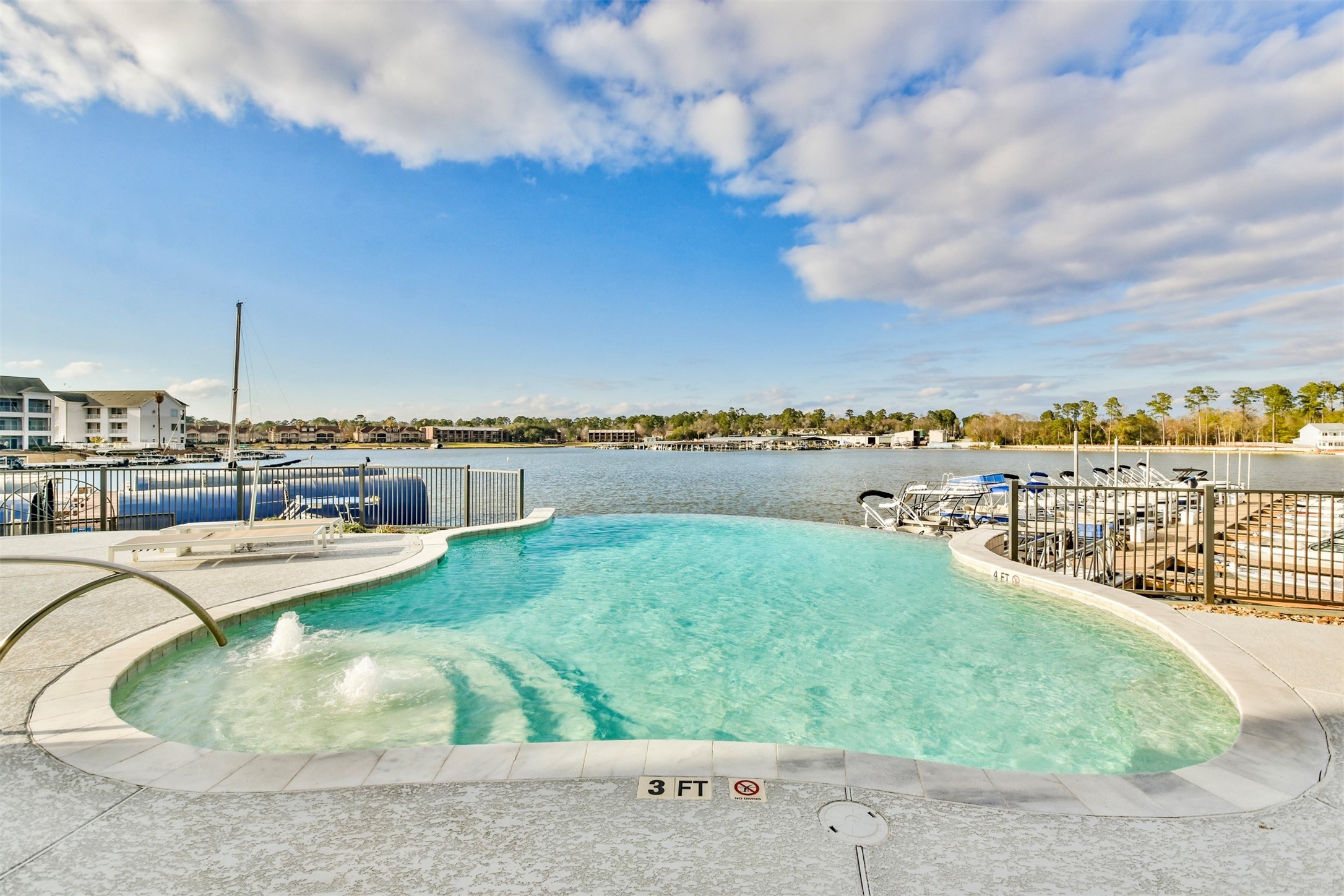 199 Waterpoint Court, Unit 106 Conroe, TX 77304 - Photo 6 of 50 Picture yourself here at the end of a long day in this Infinity Edge pool overlooking the lake--the sun sets precisely where the water ledge falls.