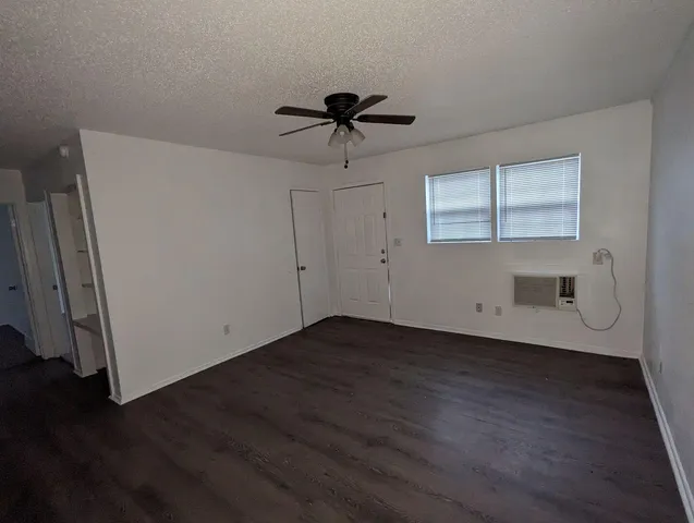 a view of a livingroom with wooden floor and a ceiling fan
