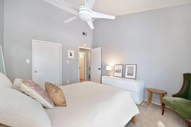 a bedroom with a large bed and a chandelier