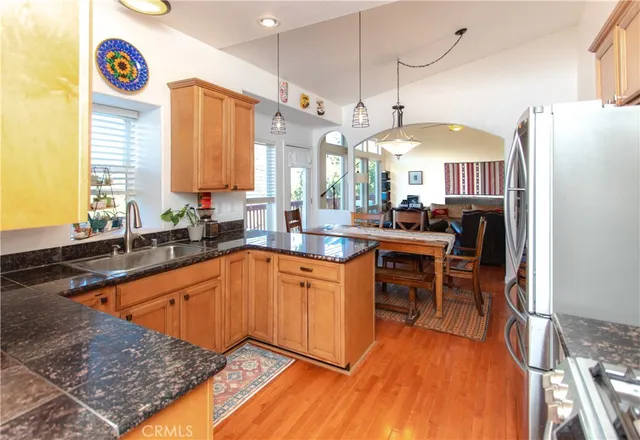 a kitchen with stainless steel appliances granite countertop a sink a stove and a refrigerator
