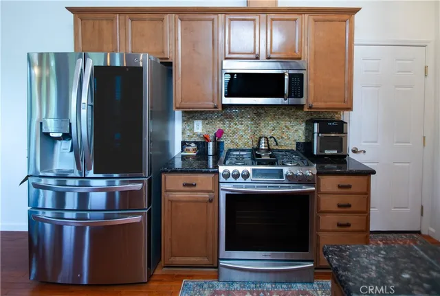 a kitchen with stainless steel appliances granite countertop a stove and a refrigerator
