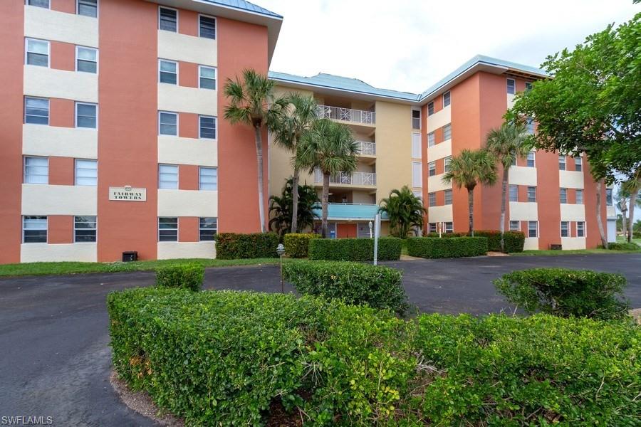 200 Pebble Beach Boulevard, Unit D402 Naples, FL 34113 - Photo 1 of 14 a front view of a building with garden