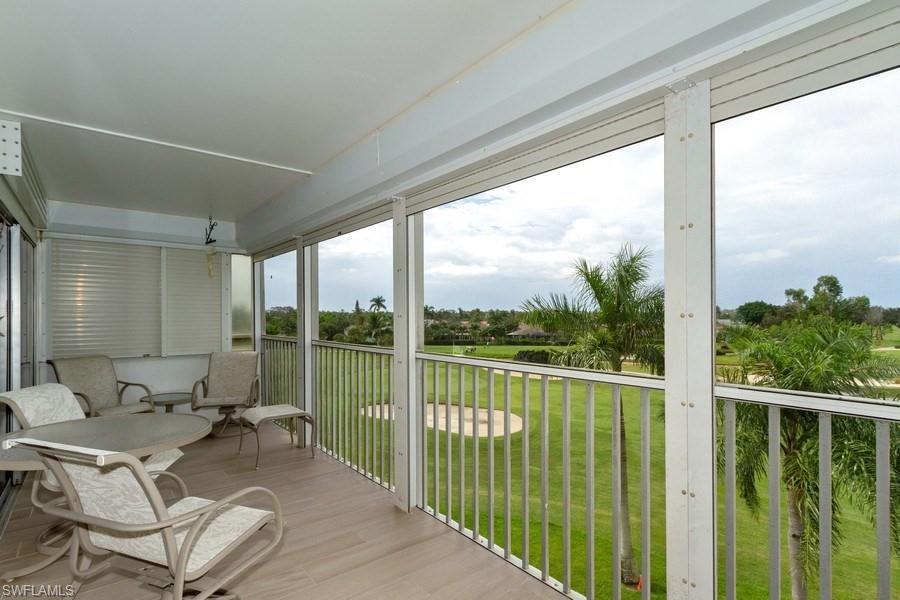 200 Pebble Beach Boulevard, Unit D402 Naples, FL 34113 - Photo 12 of 14 a view of a balcony with chairs and floor to ceiling window