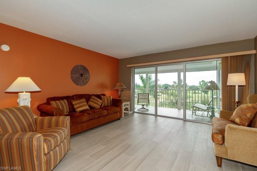 200 Pebble Beach Boulevard, Unit D402 Naples, FL 34113 - Photo 2 of 14 a living room with furniture and a large window