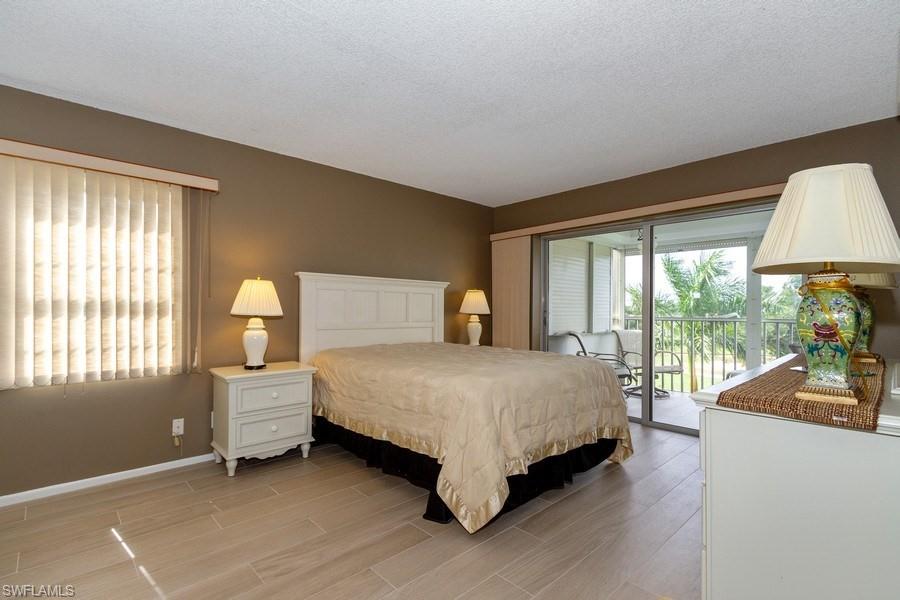 200 Pebble Beach Boulevard, Unit D402 Naples, FL 34113 - Photo 8 of 14 a bedroom with a bed and a large window