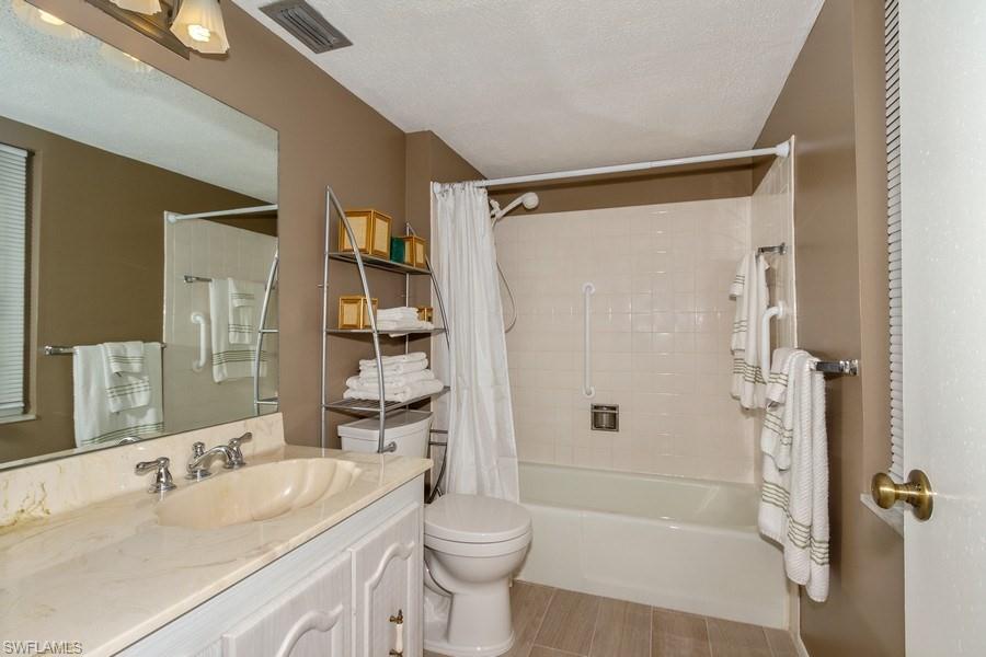 200 Pebble Beach Boulevard, Unit D402 Naples, FL 34113 - Photo 10 of 14 a bathroom with a sink a toilet and shower