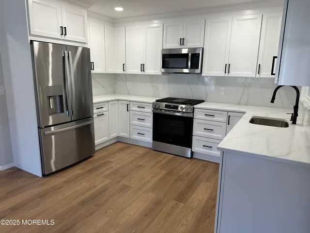 a kitchen with stainless steel appliances a refrigerator stove and sink