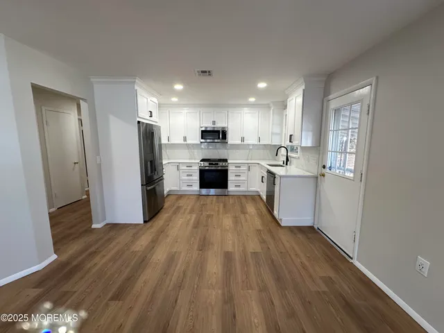 a large kitchen with a lot of counter space and stainless steel appliances