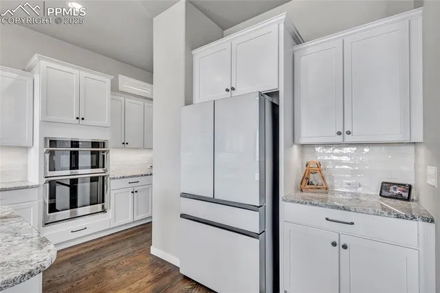 a kitchen with white cabinets and stainless steel appliances
