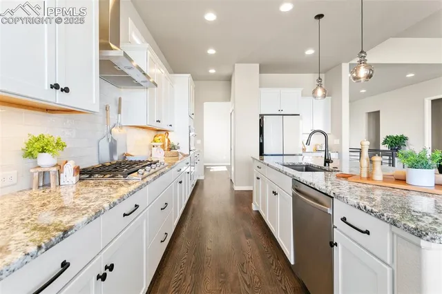 a large kitchen with granite countertop lots of counter space and a sink