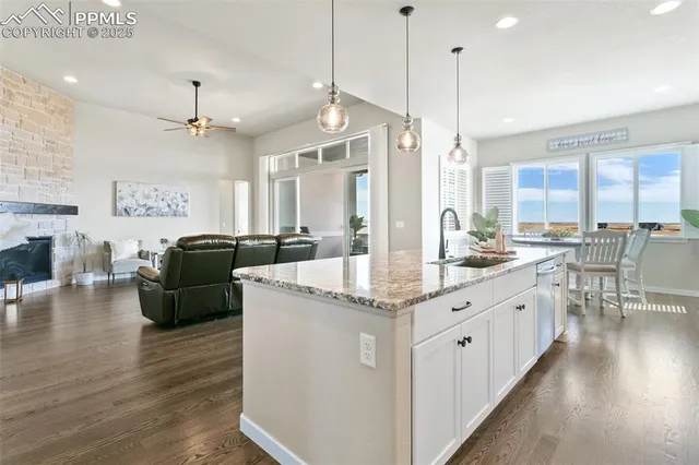 a large kitchen with granite countertop lots of counter space dining table and stainless steel appliances