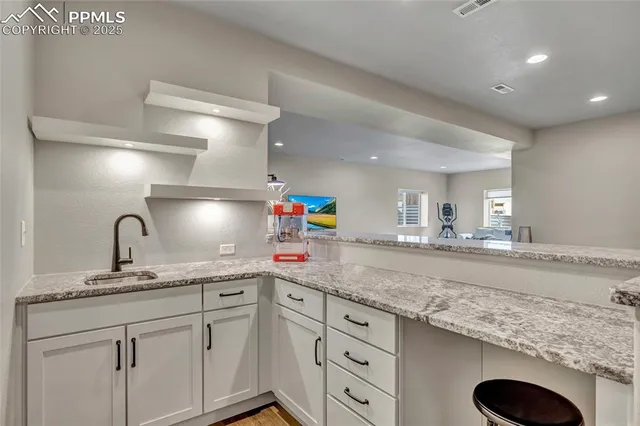 a kitchen with granite countertop a sink stainless steel appliances and cabinets