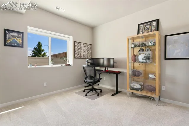 a view of a workspace with furniture and a window