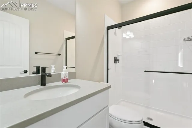 a bathroom with a granite countertop sink toilet and shower