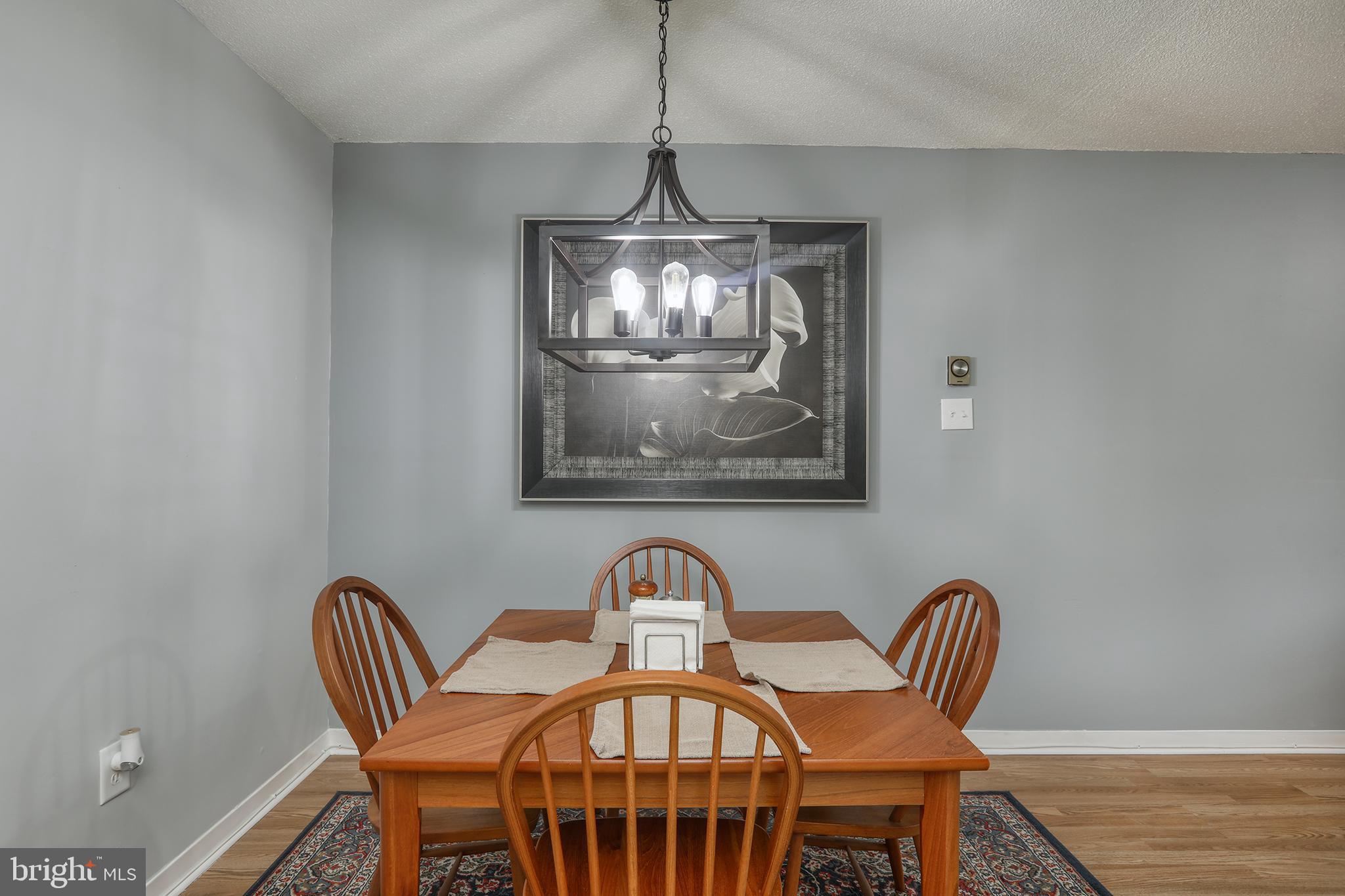 860 Lower Ferry Road, Unit 2C Ewing, NJ 08628 - Photo 11 of 19 a view of a dining room with furniture a chandelier and wooden floor