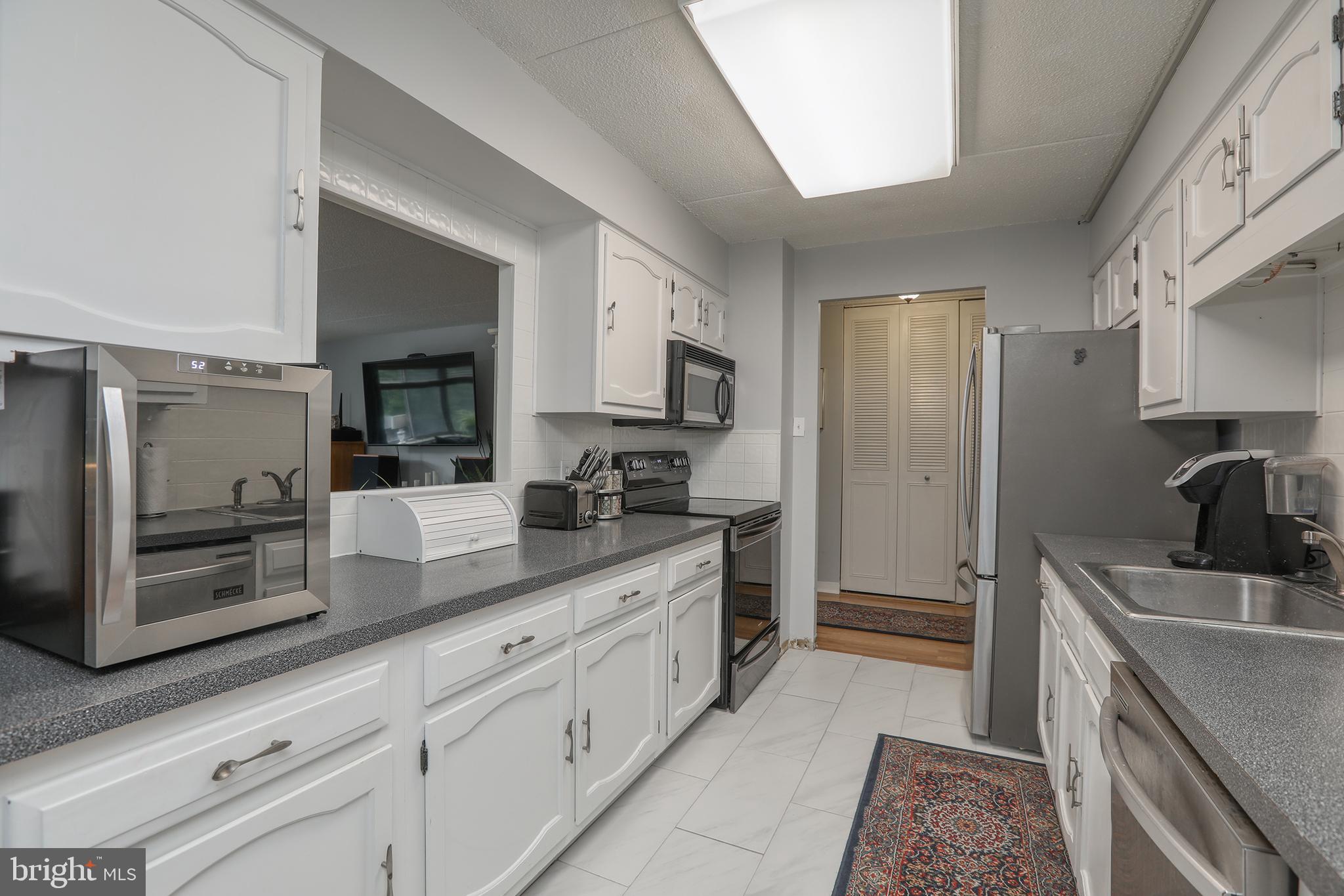 860 Lower Ferry Road, Unit 2C Ewing, NJ 08628 - Photo 8 of 19 a kitchen with granite countertop sink stainless steel appliances and cabinets