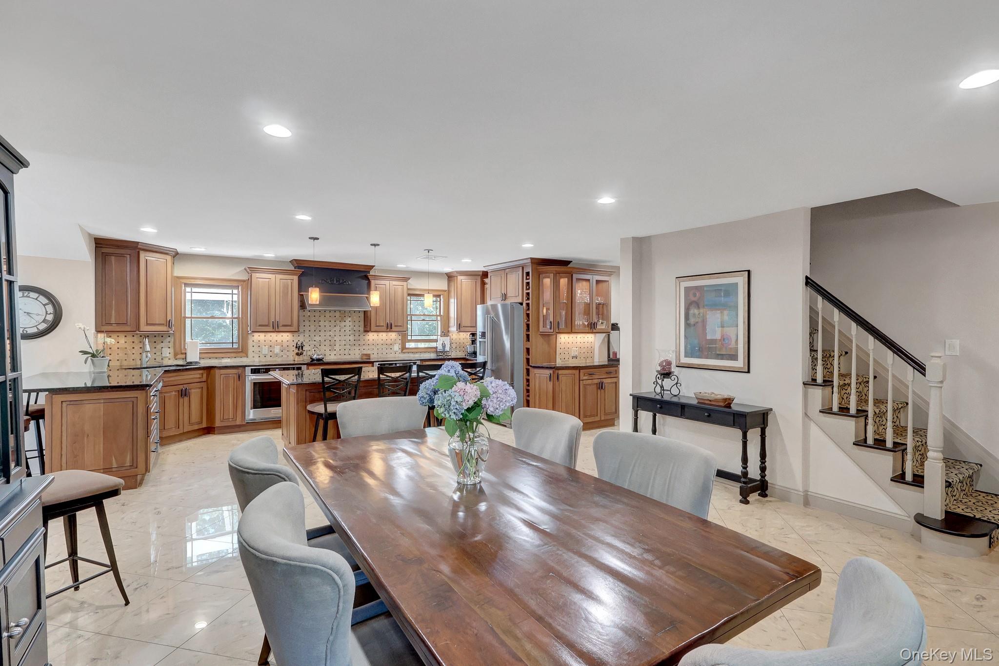 24 Fox Road East Setauket, NY 11733 - Photo 12 of 48 Spacious open-concept kitchen and dining area featuring wood cabinetry, dark countertops, and tiled flooring