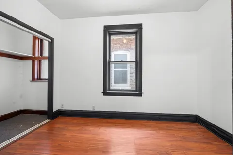 a view of a room with wooden floor and a window