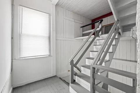 a view of an empty room with wooden floor and floors