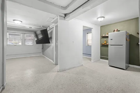 a view of a room with a refrigerator and a refrigerator