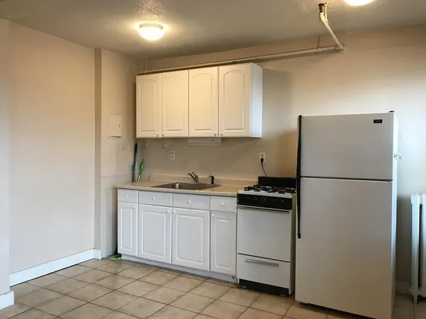 a kitchen with white cabinets and white appliances