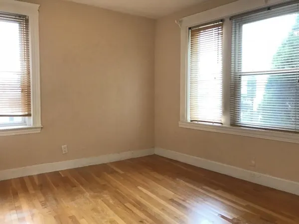a view of a room with wooden floor and a window