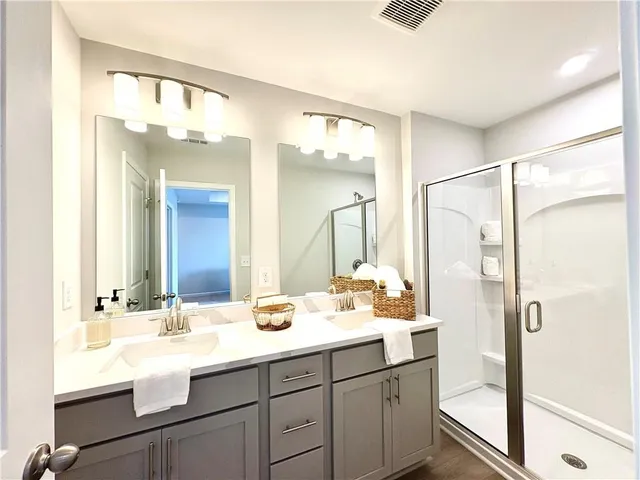 a bathroom with a granite countertop sink mirror and a shower