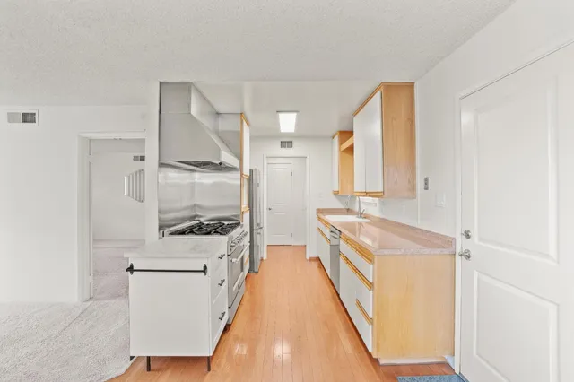 a kitchen with stainless steel appliances granite countertop a stove and a sink