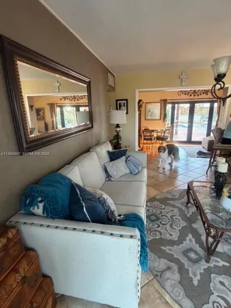 a kitchen with stainless steel appliances granite countertop a refrigerator a sink dishwasher a dining table and chairs with wooden floor