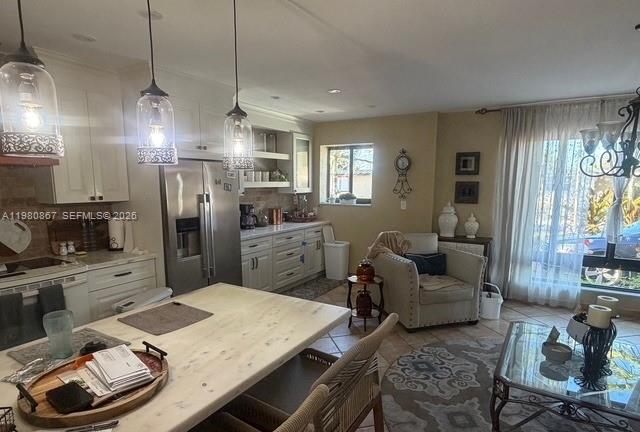 10720 Southwest 43rd Lane Miami, FL 33165 - Photo 13 of 16 a kitchen with stainless steel appliances granite countertop a refrigerator a sink dishwasher a dining table and chairs with wooden floor