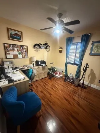 a bedroom with a bed and dresser with wooden floor