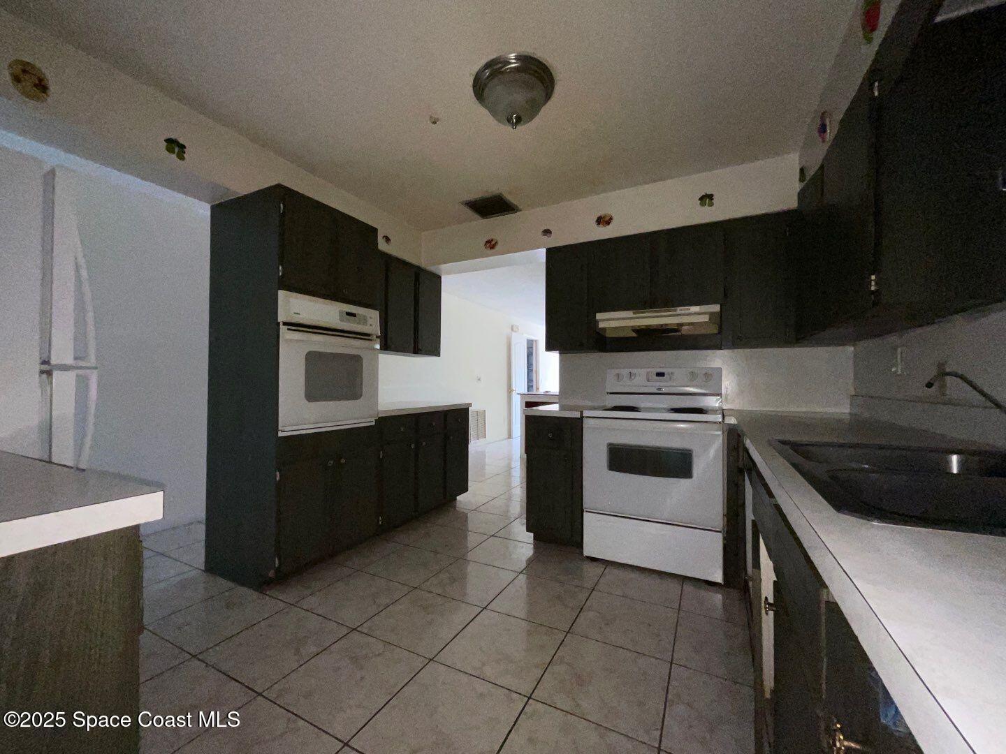 617 Walker Street Melbourne, FL 32901 - Photo 11 of 38 a kitchen with stainless steel appliances a stove a sink and a microwave