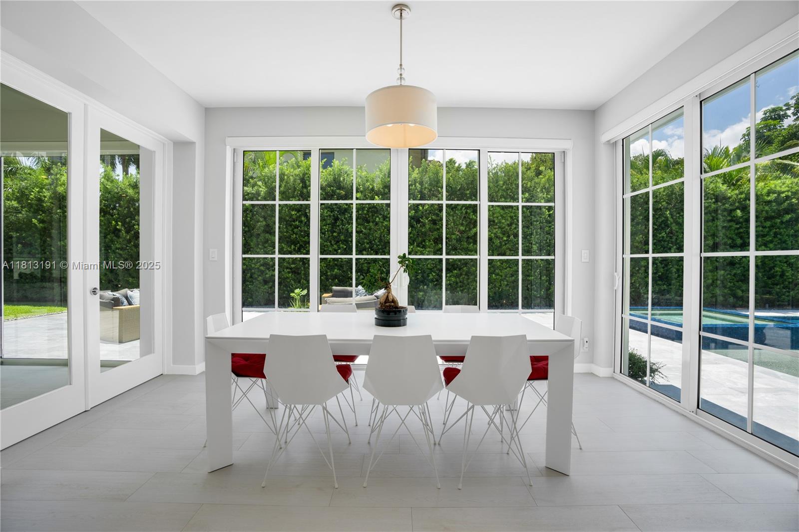 4380 Lake Road Miami, FL 33137 - Photo 23 of 41 a view of a dining room with furniture large windows and wooden floor