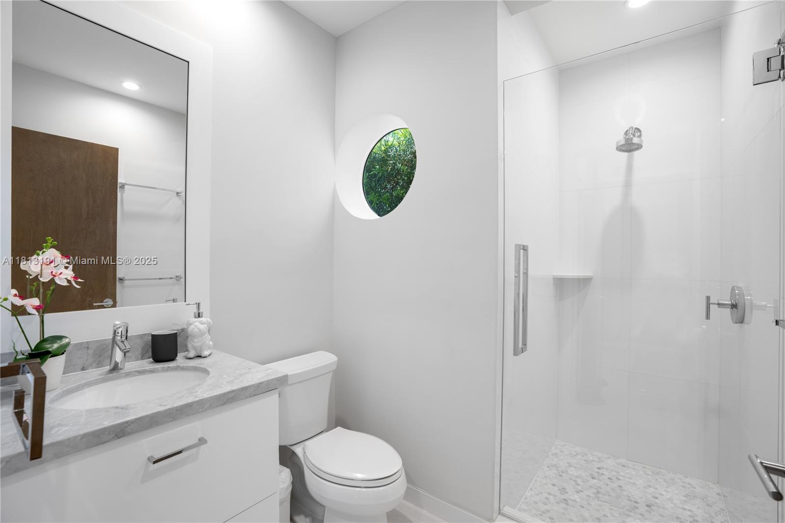 4380 Lake Road Miami, FL 33137 - Photo 29 of 41 a bathroom with a toilet a sink and mirror