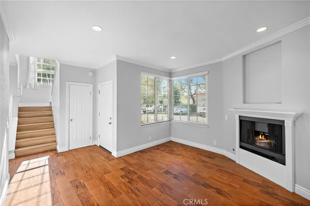 a view of empty room with wooden floor and fireplace