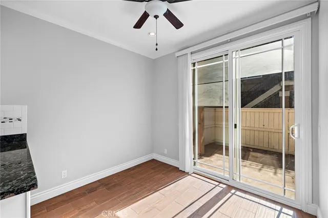 a view of a big room with wooden floor and windows