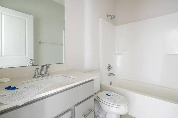 a bathroom with a granite countertop sink a toilet and a bathtub