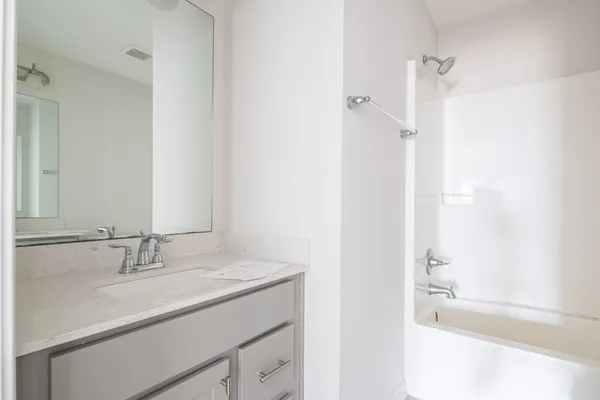 a bathroom with a tub sink and a mirror