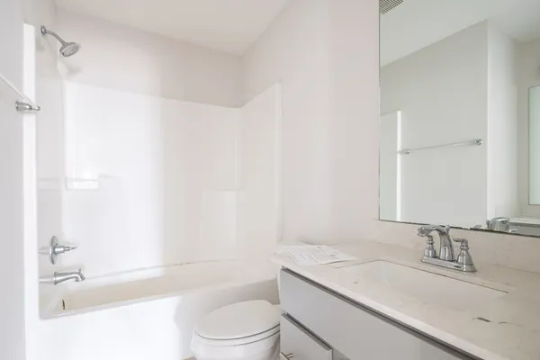 a bathroom with a granite countertop sink toilet and shower