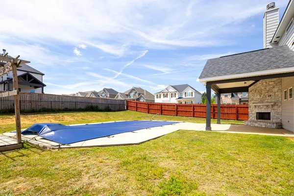 a view of swimming pool with lawn chairs and large trees