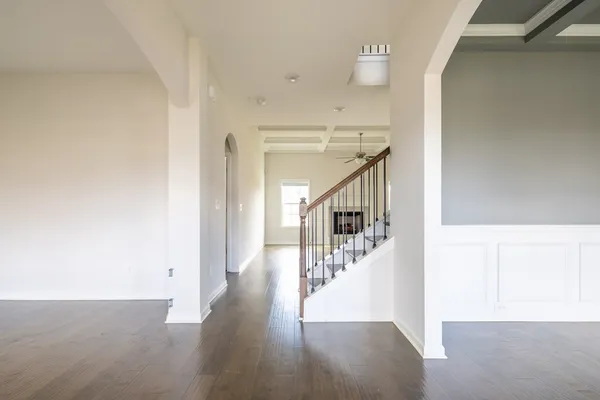 a view of a hallway with wooden floor and staircase