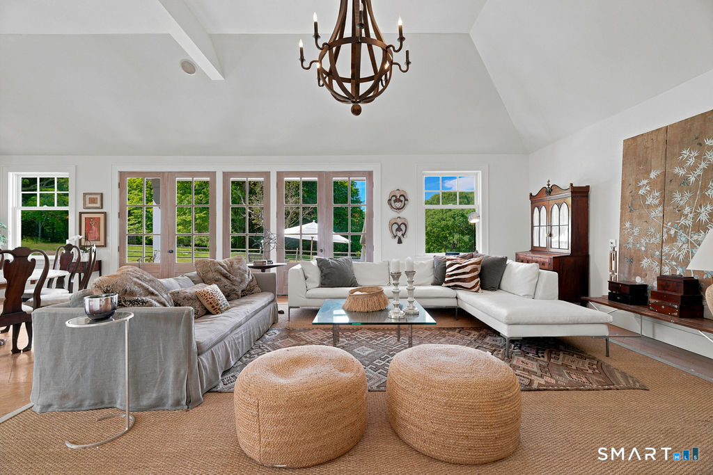 261-1 Grassy Hill Road Lyme, CT 06371 - Photo 6 of 40 Walls of windows and multiple doors blur the line between indoors and out, showcasing breathtaking views and immersing the home in the beauty of its surroundings throughout the year.