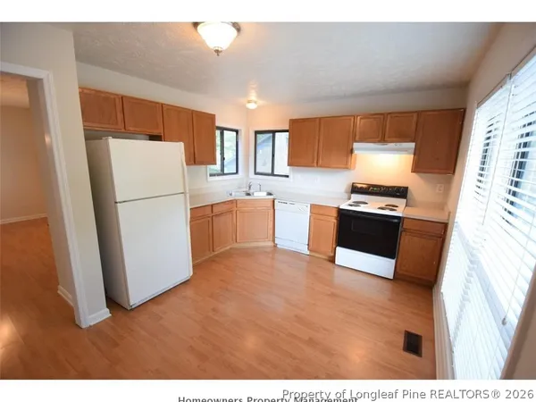 a kitchen with stainless steel appliances granite countertop a refrigerator stove top oven and sink