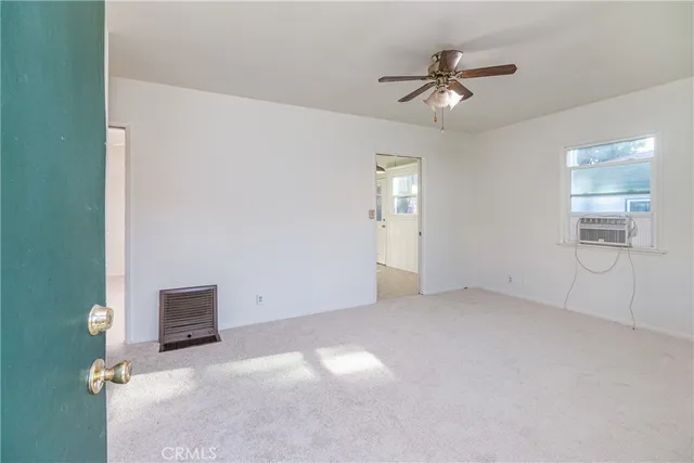an empty room with a ceiling fan and a window