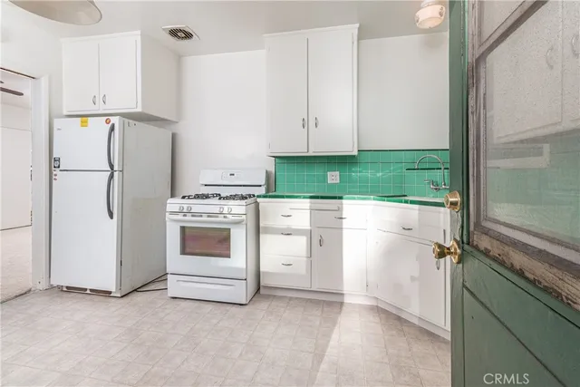 a kitchen with white cabinets and white appliances