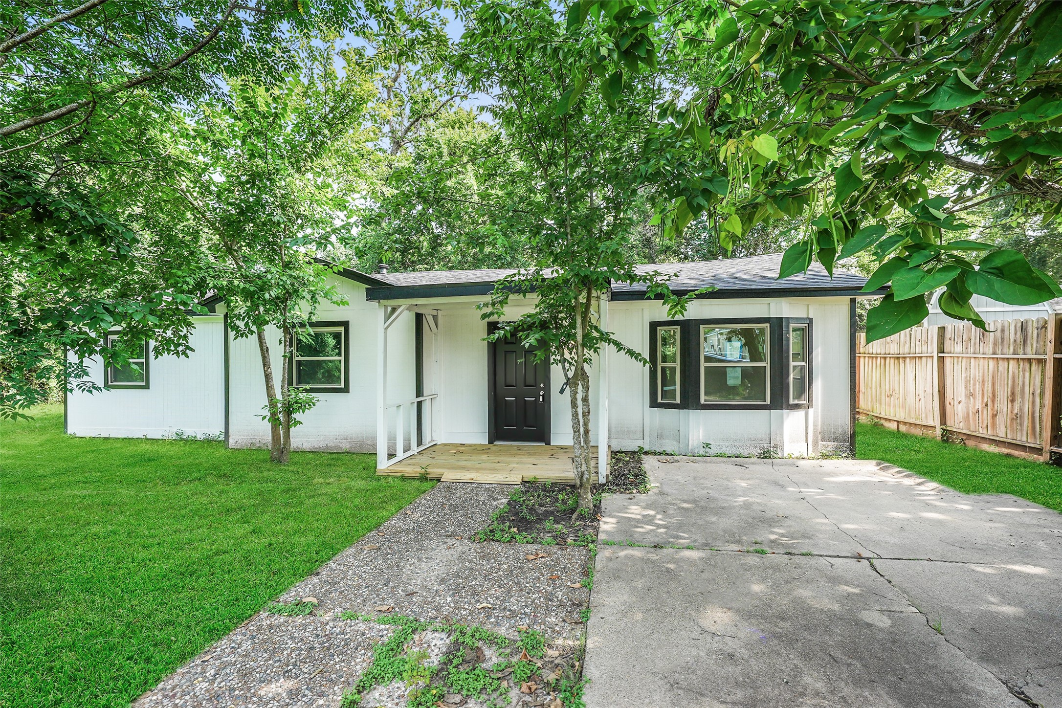725 Lafayette Street Hempstead, TX 77445 - Photo 2 of 20 Front elevation featuring a covered porch, mature landscaping, and a spacious front yard