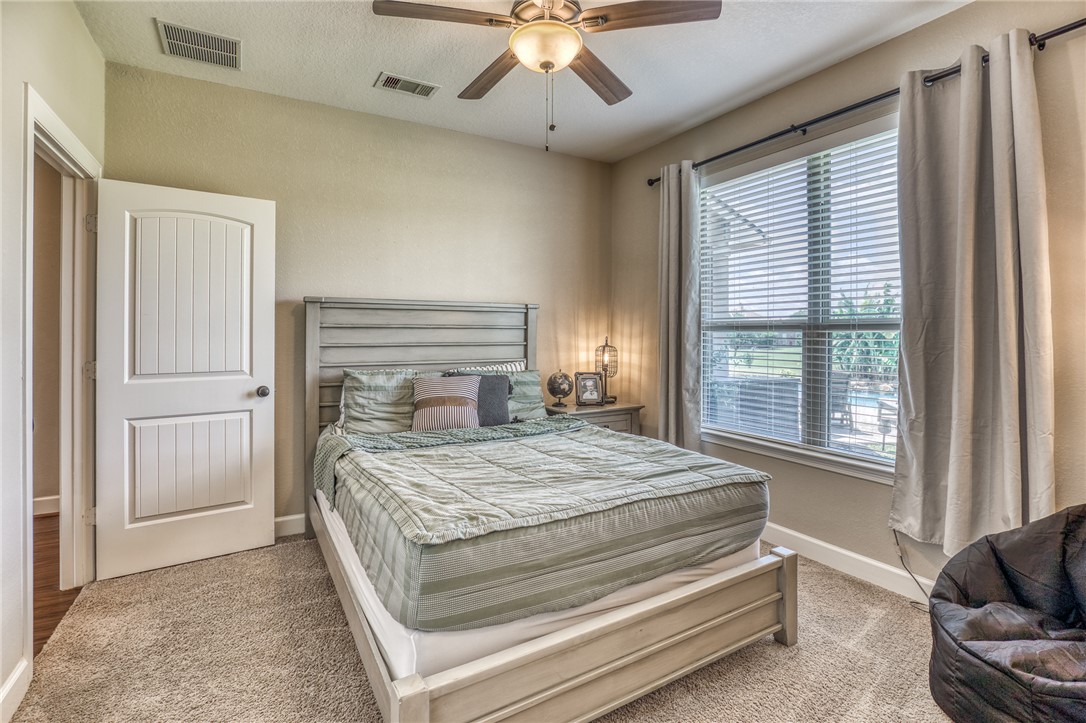 586 Ruby Drive Bellville, TX 77418 - Photo 26 of 50 a bedroom with a bed and a chandelier