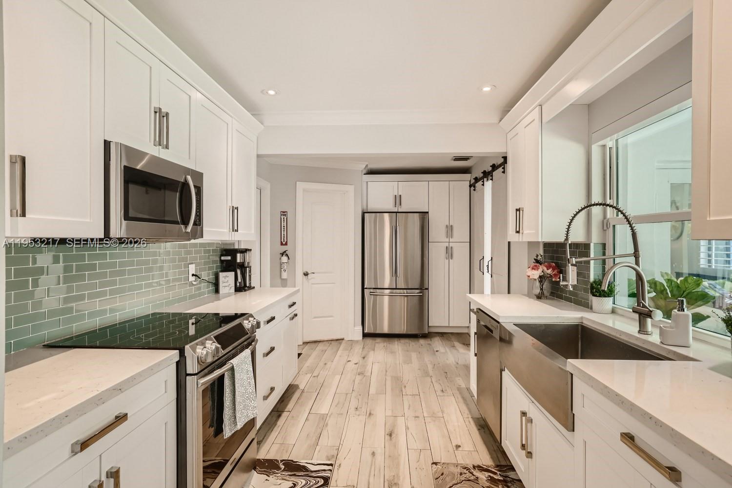 5117 Cleveland Street Hollywood, FL 33021 - Photo 14 of 39 a kitchen with granite countertop a sink appliances and cabinets