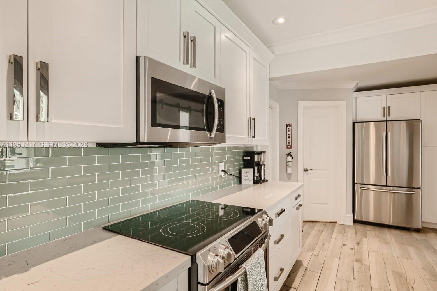 5117 Cleveland Street Hollywood, FL 33021 - Photo 16 of 39 a kitchen with granite countertop a stove and a refrigerator