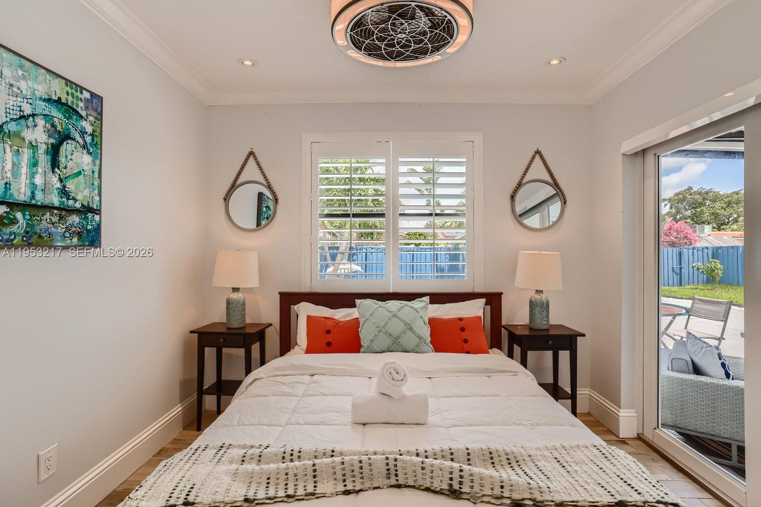 5117 Cleveland Street Hollywood, FL 33021 - Photo 27 of 39 a bedroom with a bed a dresser and a large window